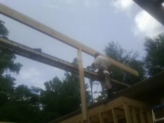 Carpenter setting a ridge beam over a new addition frame — Ice Dam Removal by Roofing Brothers in Duchesne