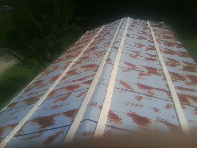 Rusted metal roof panels with new wood purlins before replacement — Storm Damage Roof Repair in Duchesne by Roofing Brothers