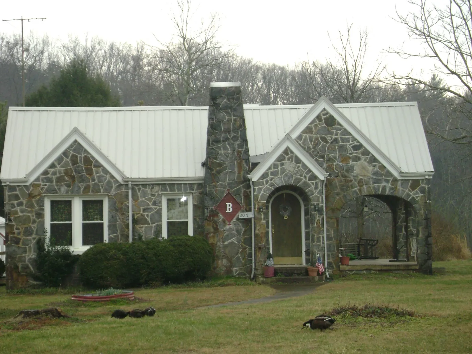 White metal roof on a stone cottage with steep gables in Duchesne