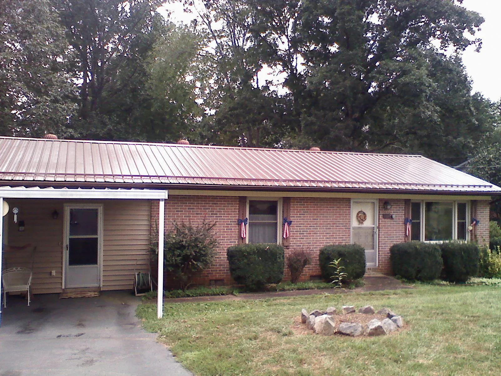 Bronze metal roof and carport on a brick ranch home — Roof Repair work by our crew in Duchesne